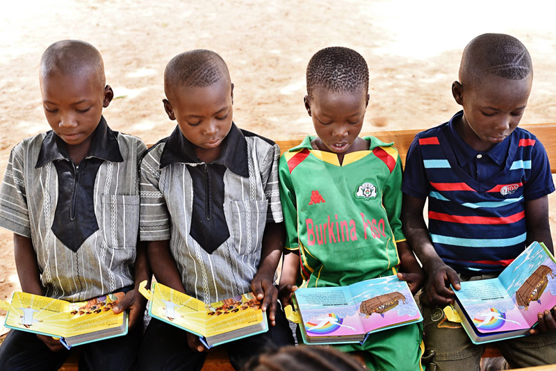 Little boys read their first Bibles together