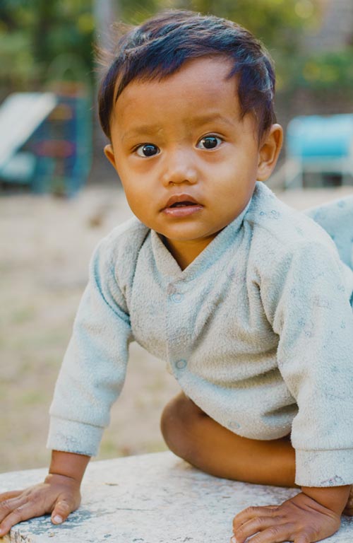 A toddler from Thailand playing outside