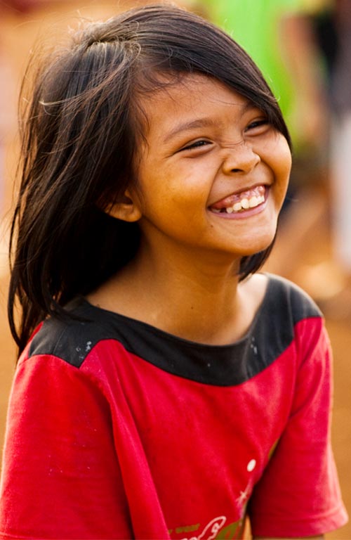 A young girl wearing a red top smiling