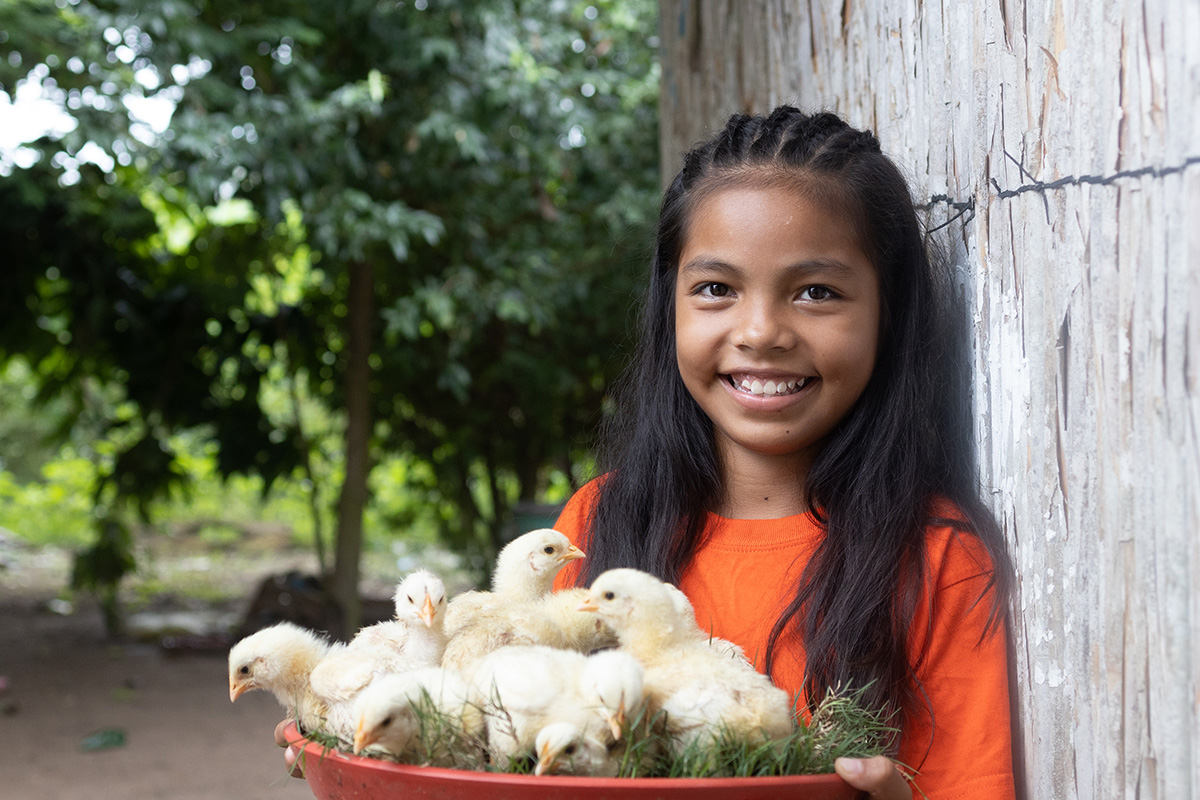 a girl holds baby chicks
