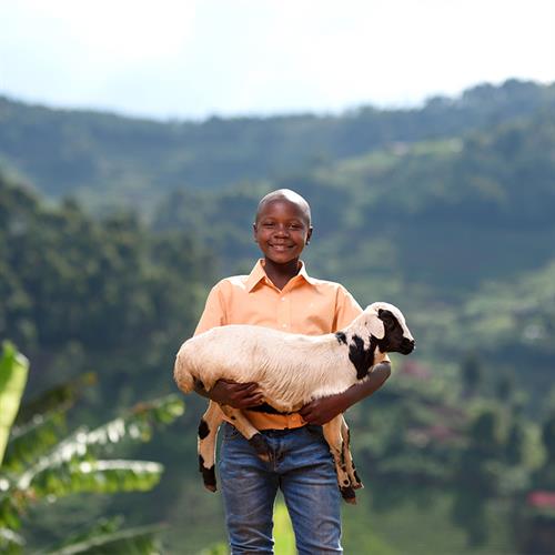 child smiles while holding goat