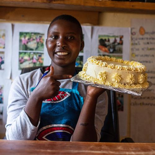 Young girl shows off the cake she baked. 