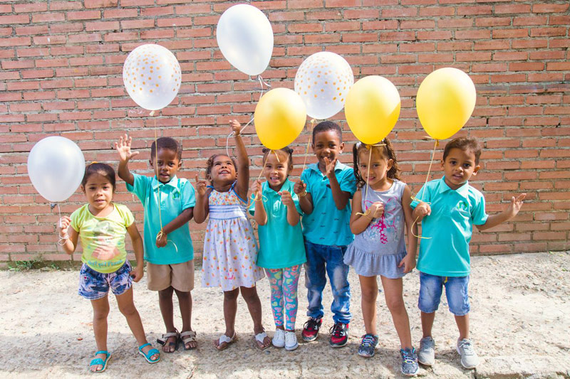 A group of children celebrate New Year’s Eve with colorful balloons
