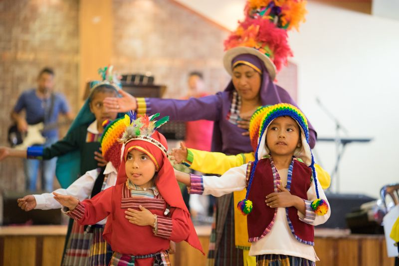 Children wear traditional Ecuadorian clothes as they dance on a festive occasion