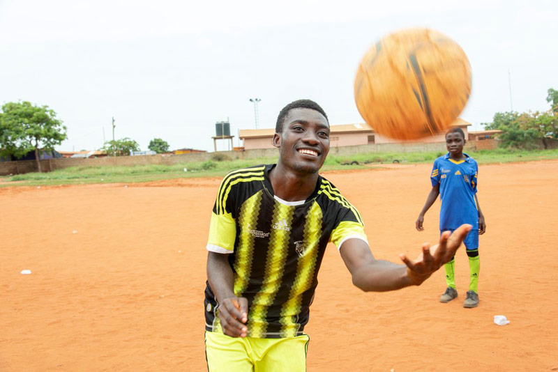 A young man plays with a soccer ball