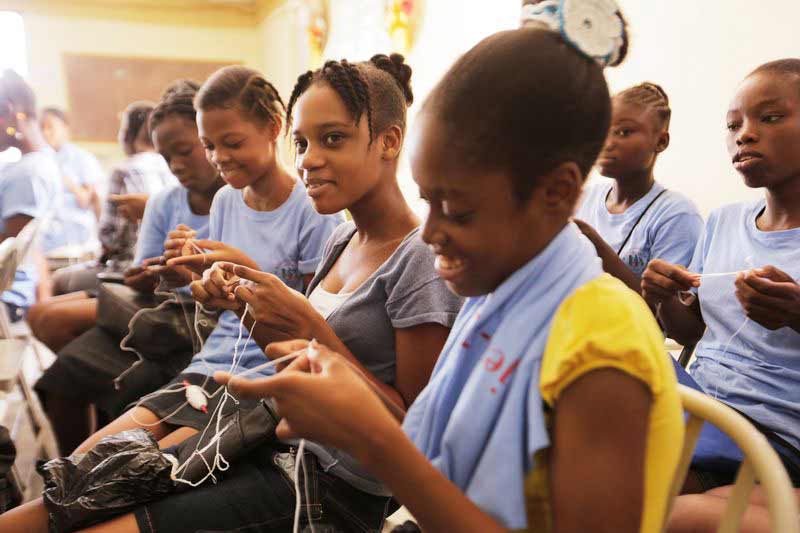 A group of young women learn vocational skills at their child development center