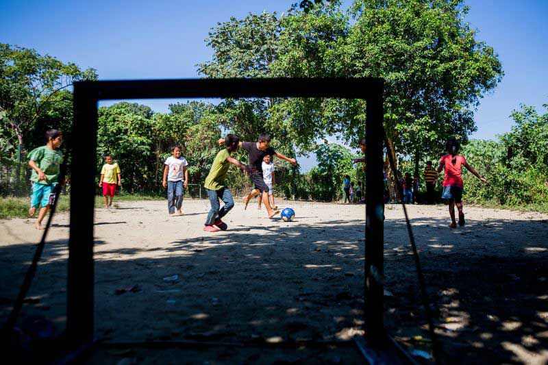 A group of boys play soccer at their child development center