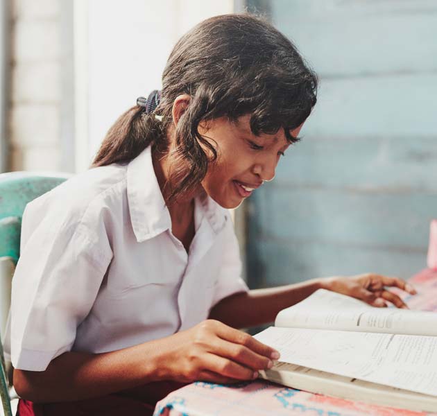 A girl reading a book in her school