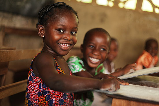 A young girl sitting at her desk and smiling in school