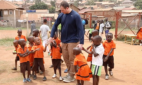 Nate Solder playing with a group of Compassion children