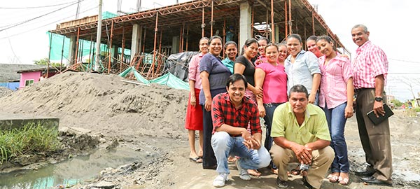 a group of people standing in front of a building being built