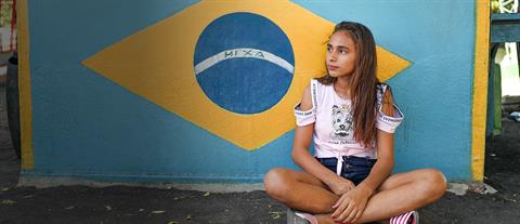 a girl sits against a wall