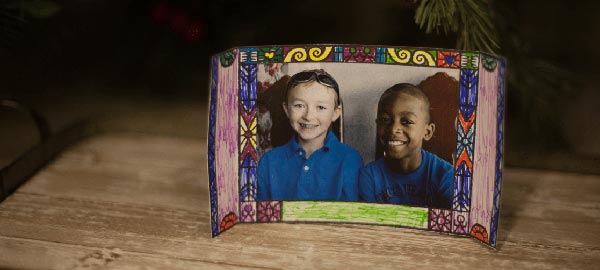 A homemade picture frame with a picture of two boys in blue shirts
