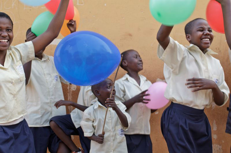 Children laugh and play with balloons