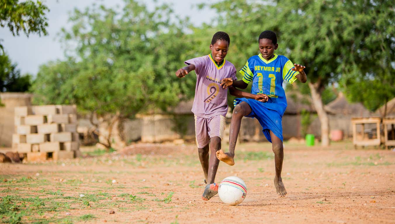 Two boys playing soccer in Burkina Faso