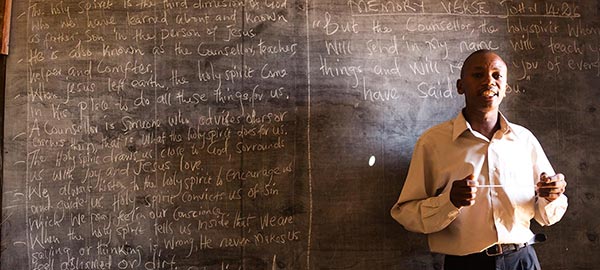 a teacher standing in front of a chalkboard