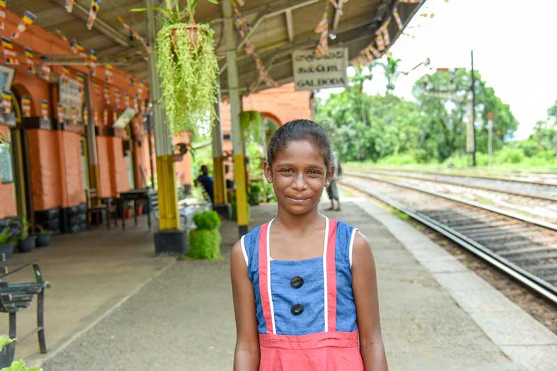 A girl stands outside the trainstation