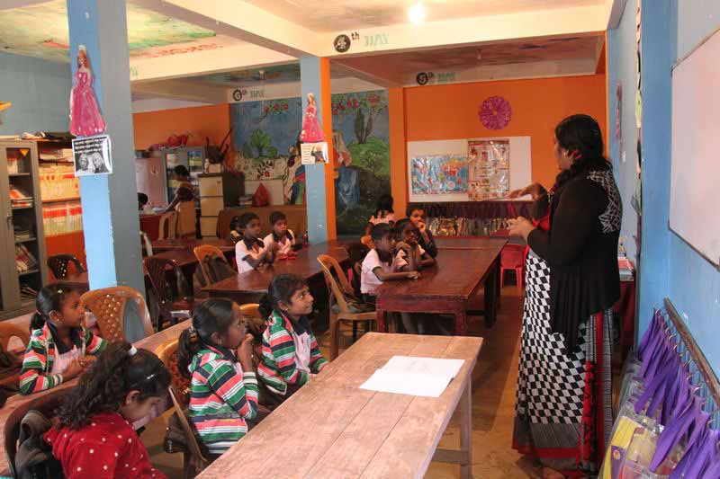 A teacher standing in front of students in classroom