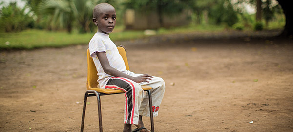A boy sitting outside in a chair