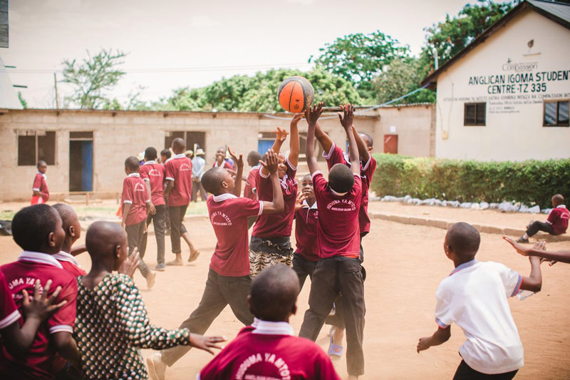 A group of students play basketball