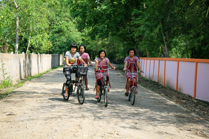 A group of girls ride bicycles