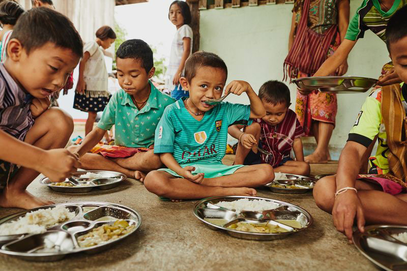 A group of children eat a meal at their child development center