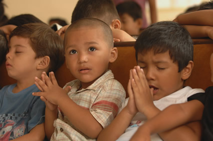 three young children praying