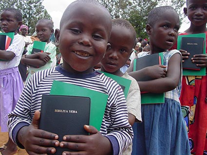a line of children holding bibles