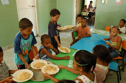 young children serving food to other children