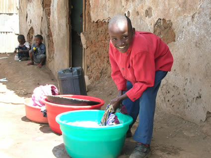 a boy washes clothes in a bucket