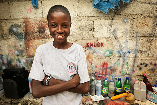 A young boy smiling with his arms folded