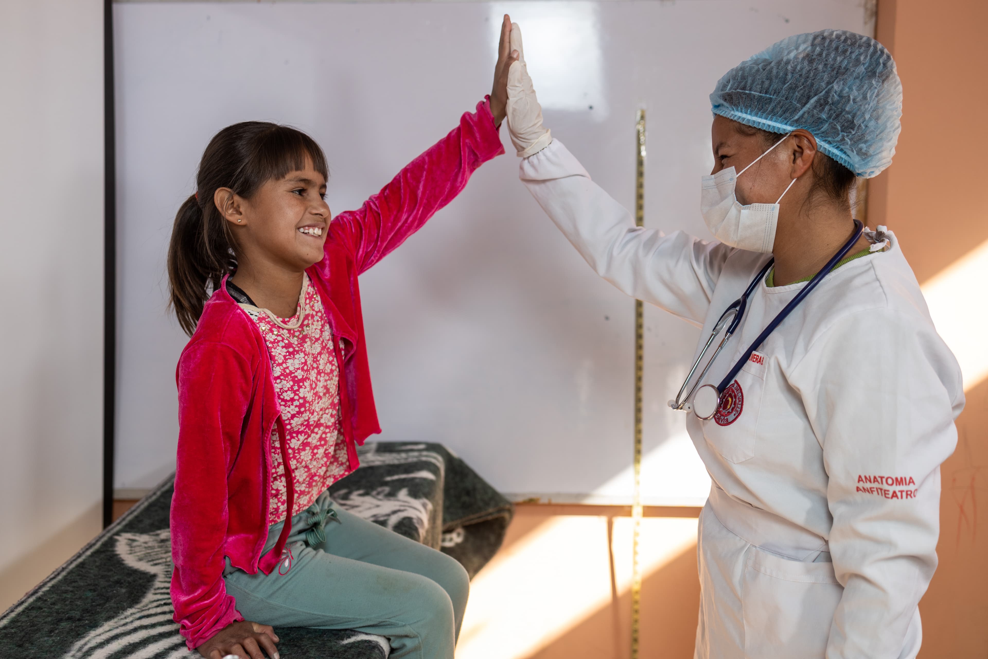 Young girl gives the doctor a high five after a medical check up.