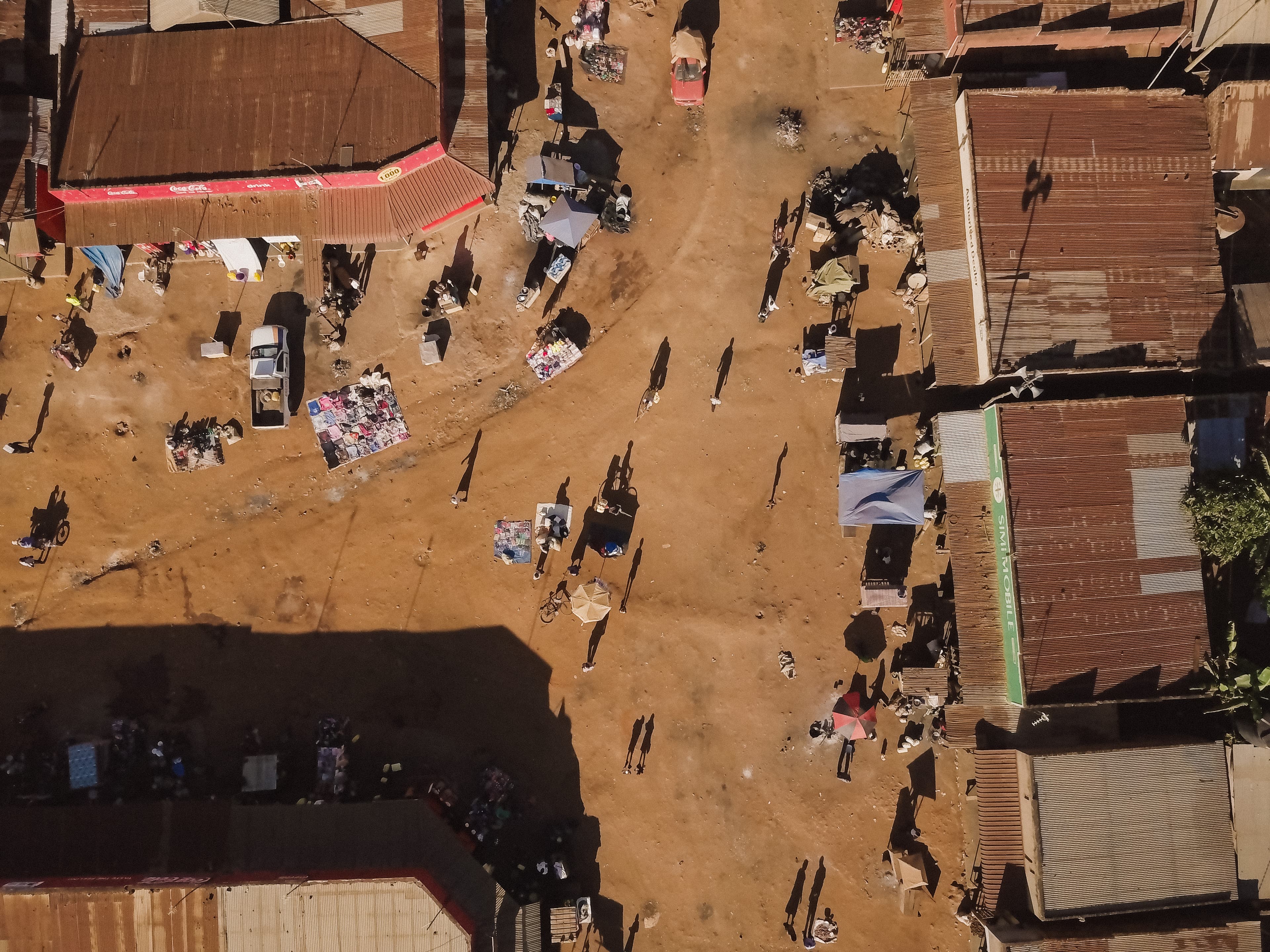 A busy neighborhood captures from above featuring buildings and groups of people.