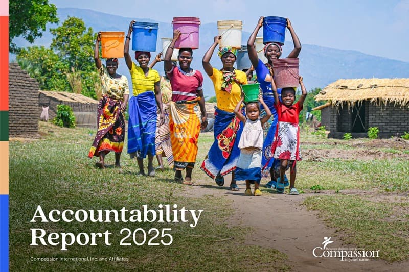 Group of women and children carrying buckets in front of a mountain