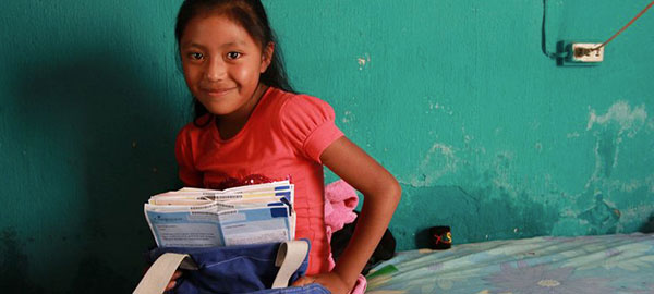 A young girl holds letters from a sponsor