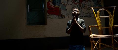 A boy kneeling in prayer