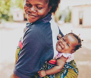 Mom and baby smiling together.