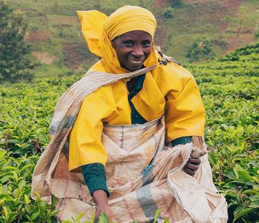 A woman holds a bag wearing a yellow raincoat