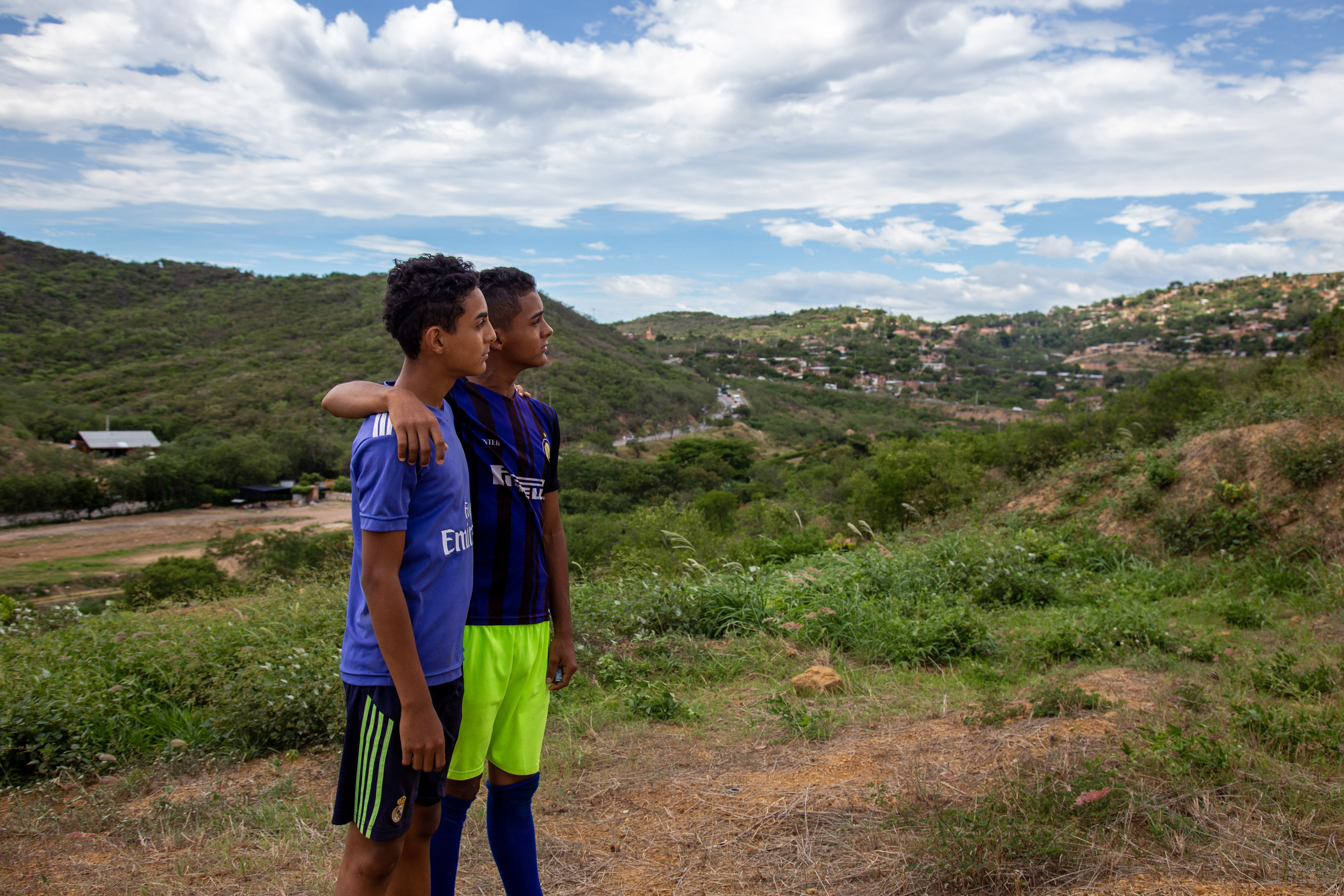 2 teens look out over the horizon at the Colombia Venezuela border