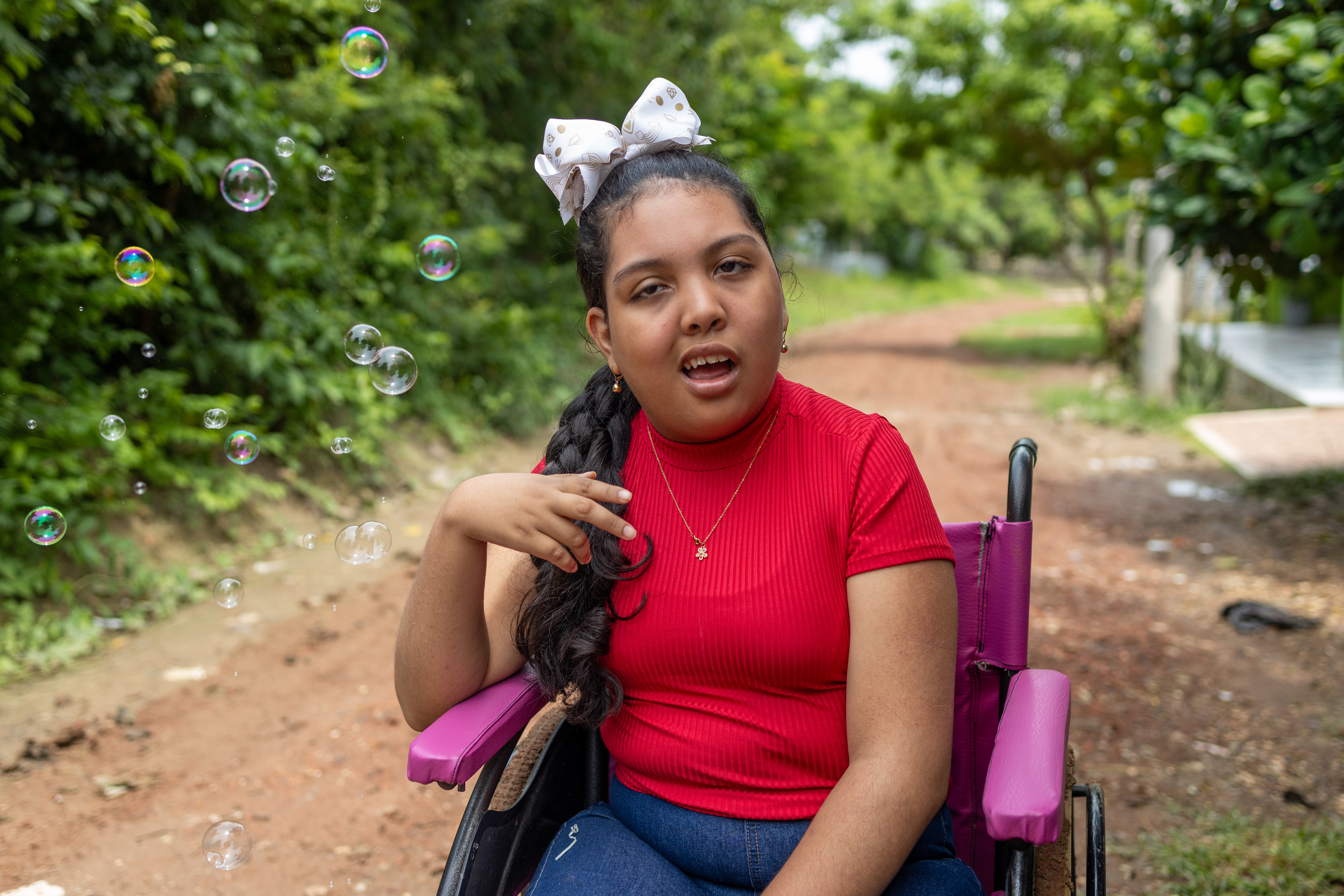 Melany sits in her pink wheel chair 