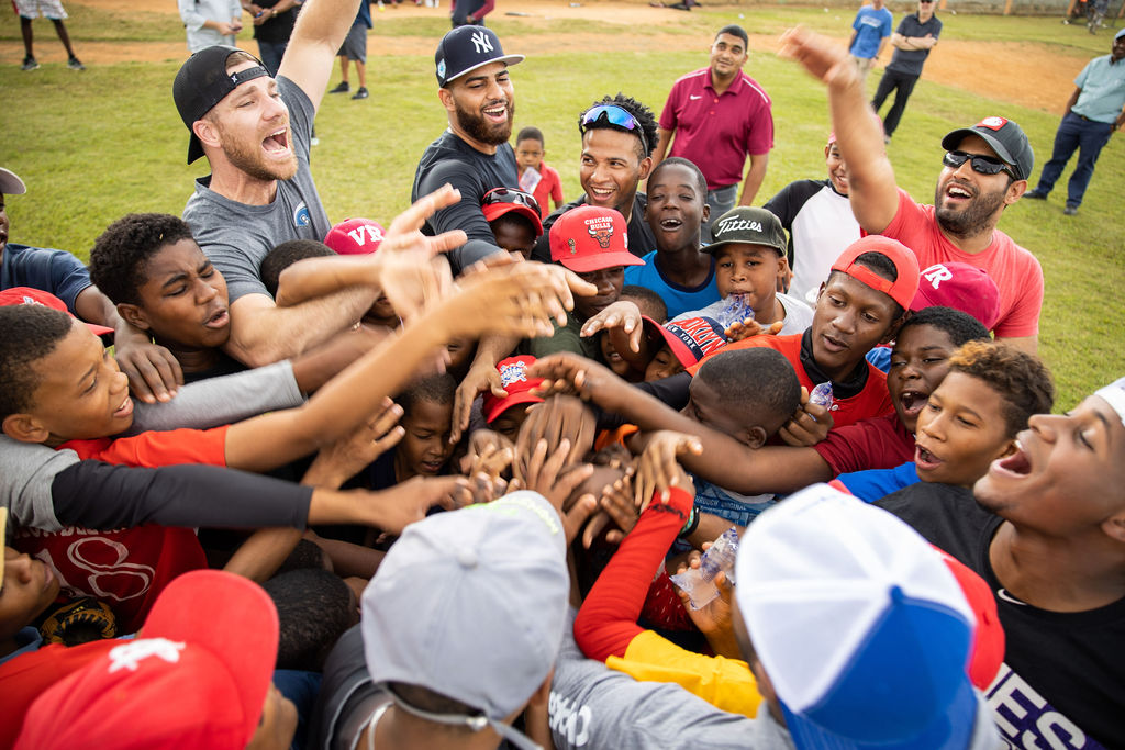 Children and pro athletes join hands before game in Dominican Republic