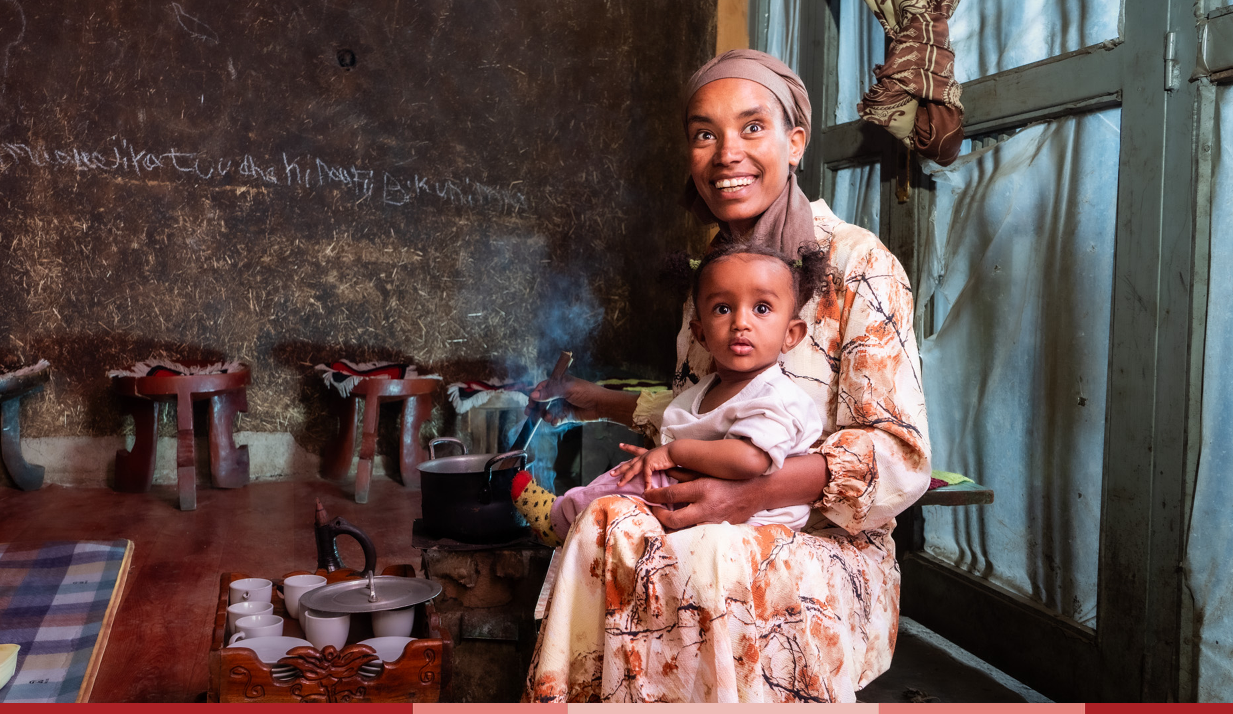 Tirunesh holds her baby in her lap and smiles brightly