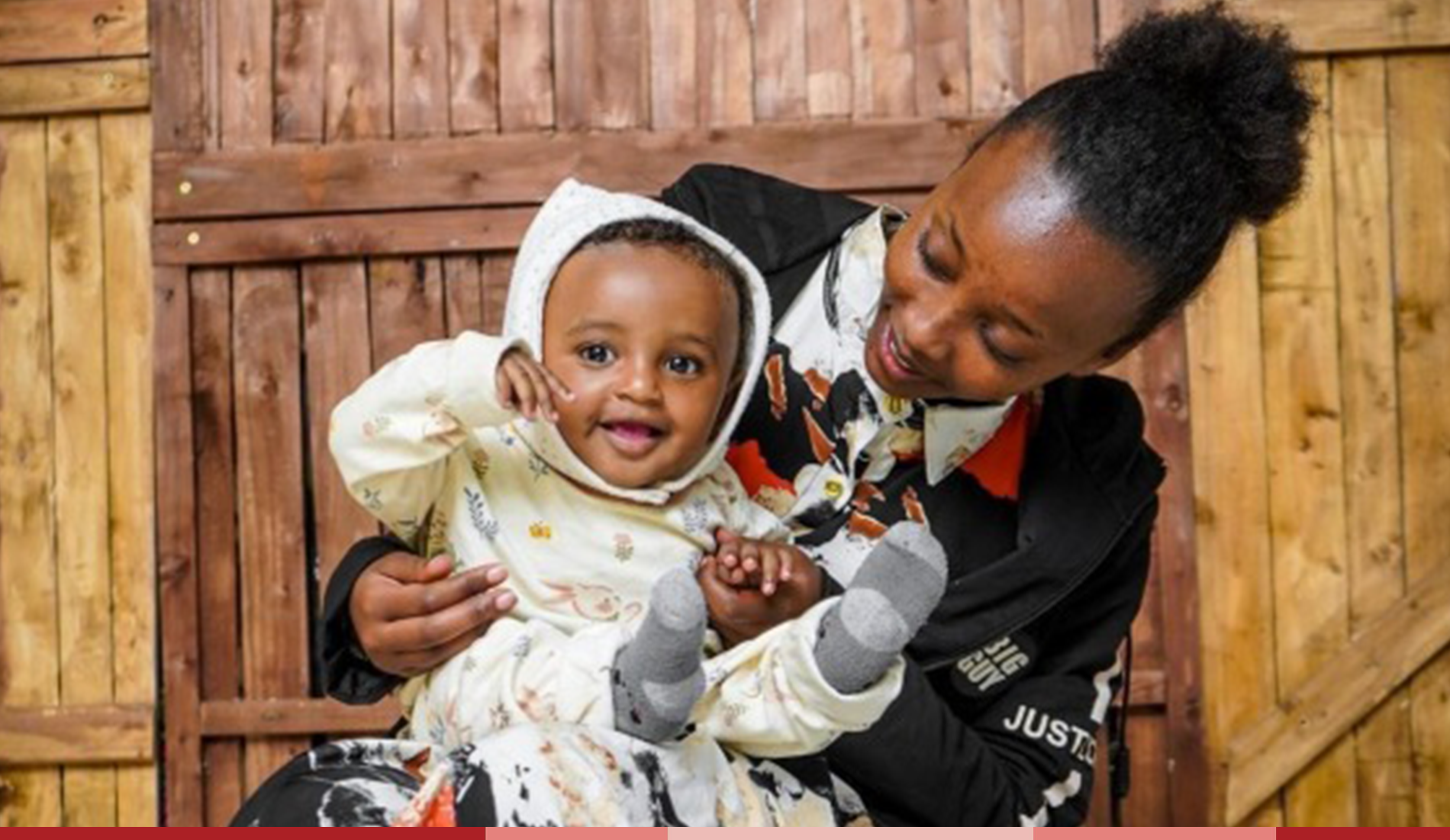 Baby Barnabas smiles brightly at the camera while Zertihun holds him
