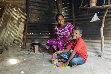 Woman sits with child playing with toys
