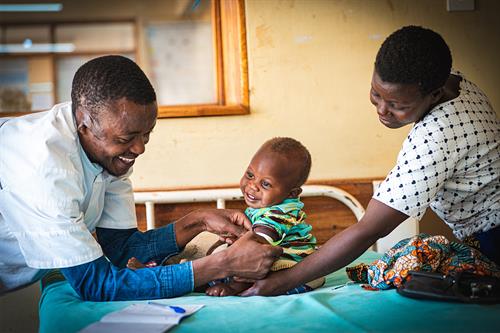 A nurse is conducting MUAC measurements on Vincent.