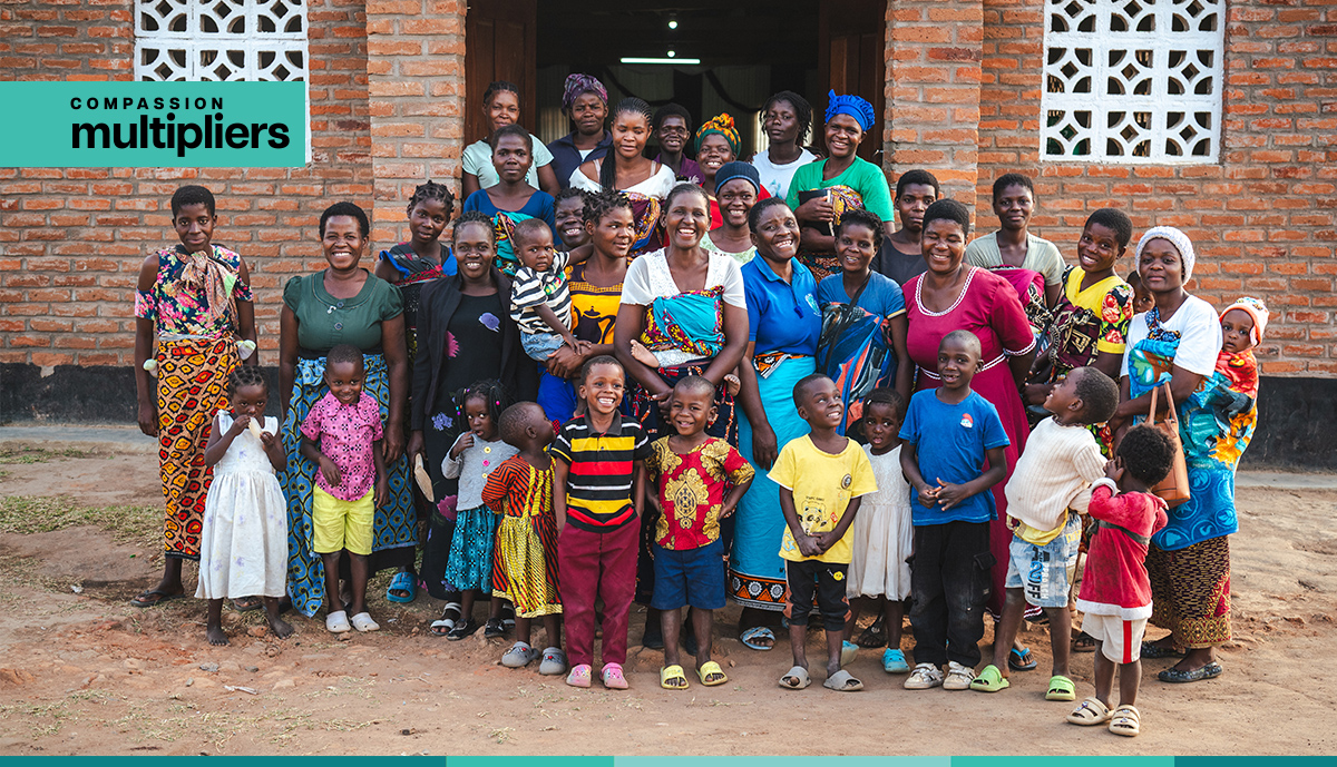Compassion Multipliers - Pastor Beauty with some of the Caregivers and Program Participants standing in front of the church FCP in Malawi.