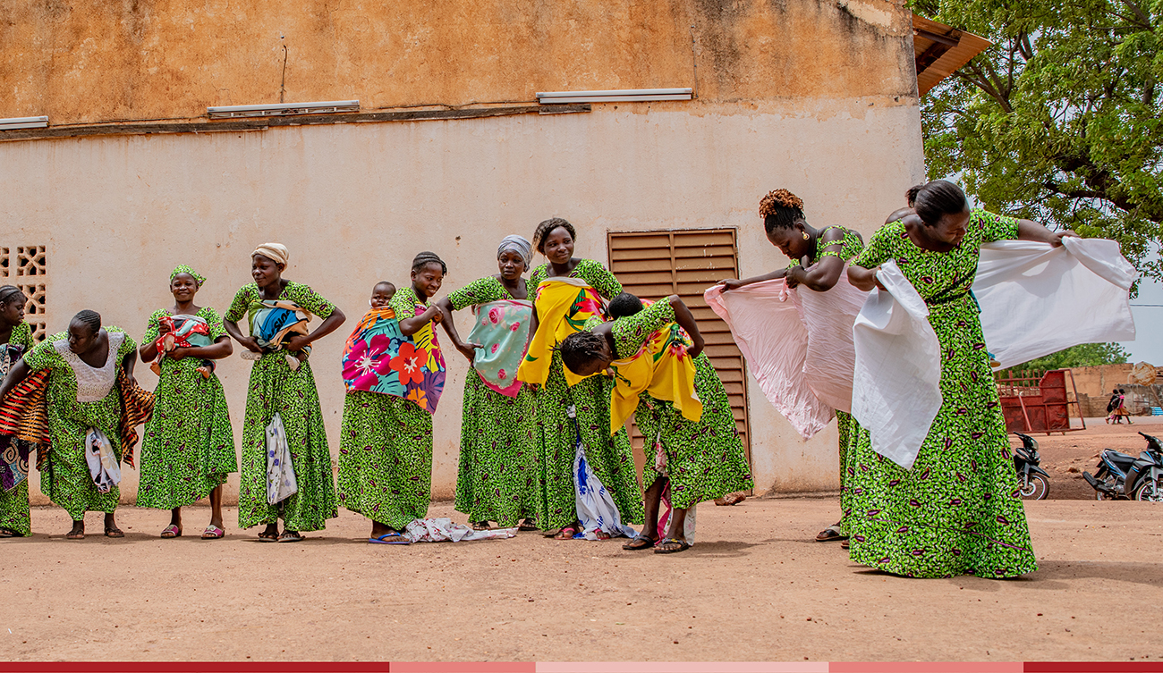 A group of moms wrap their babies in traditional baby wraps 