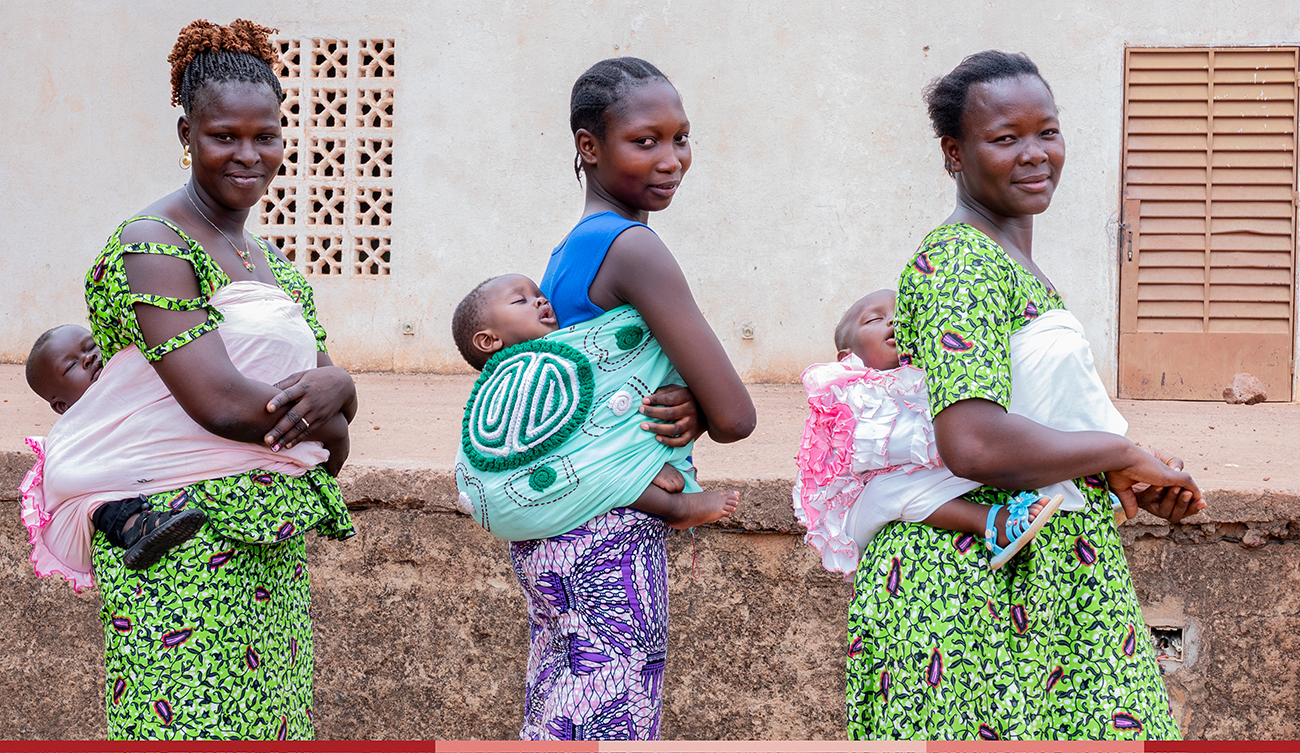 A group of moms show how they carry their babies using traditional baby wraps
