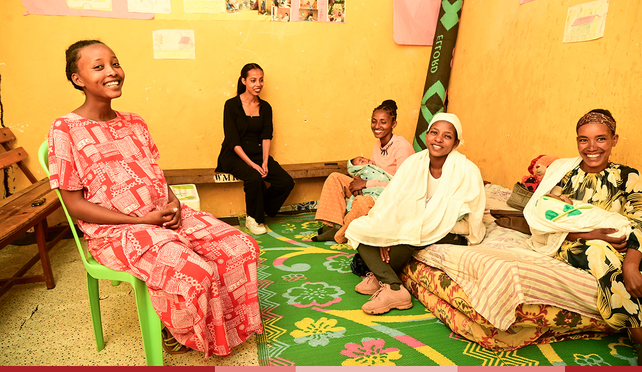 a group of moms sit together at the Nurturers Center and smile