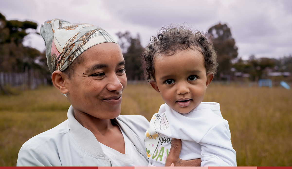 Tirunesh looks at her daughter who is smiling at the camera